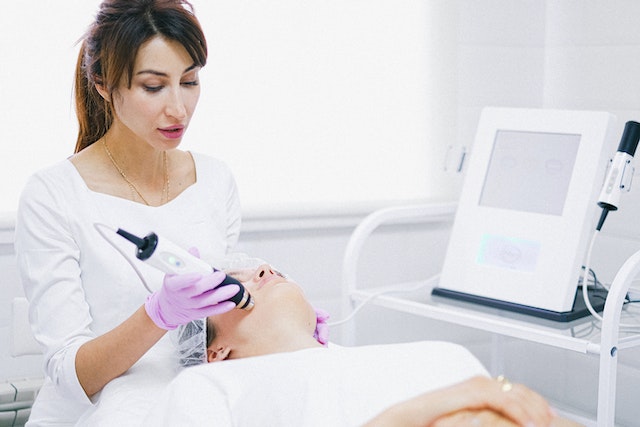 haciendo una depilación laser a una chica en el rostro